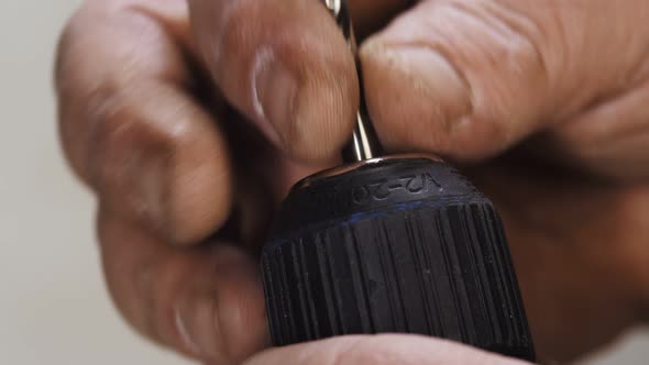 Mans Hand Inserted Drill Bit Into Screwdriver and Fixed Closeup