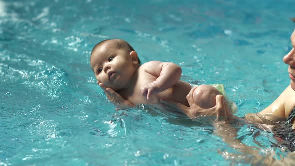 Baby on a Hands Swimming in Water