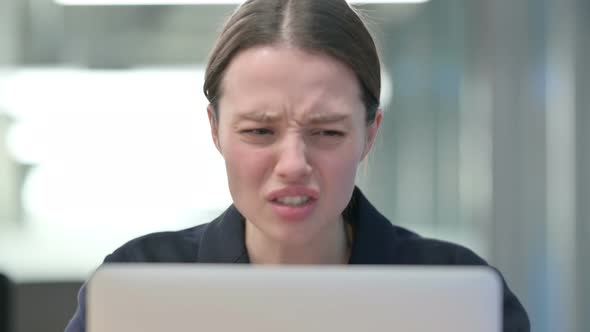 Portrait of Young Businesswoman Reacting to Loss While using Laptop