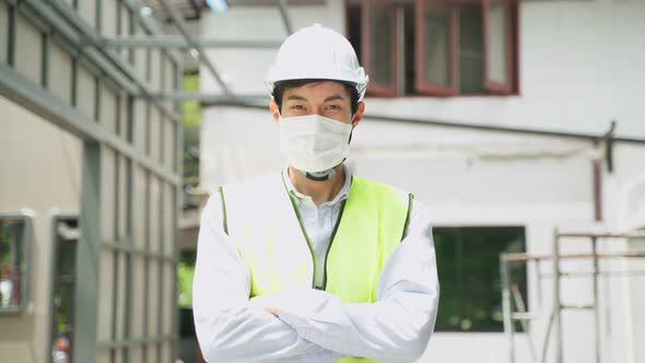 Asian man worker people wearing protective face mask onsite of architecture due to covid pandemic.