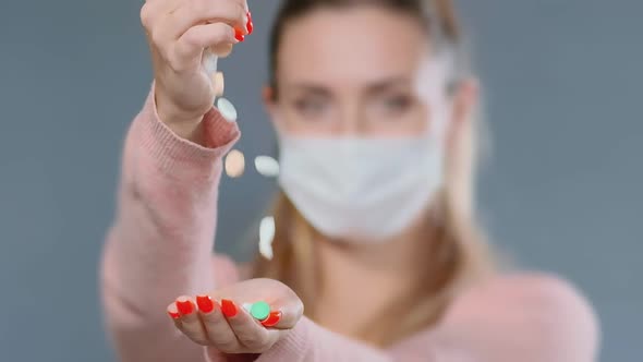 Blurry Long Haired Lady in Mask Throws Pills Into Palm