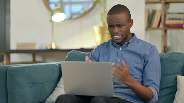 Angry Young African Man Feeling Disappointed on Laptop