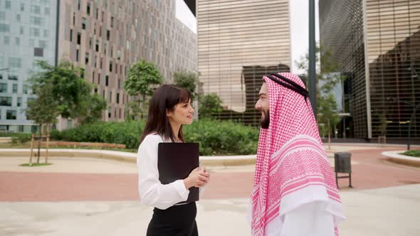 European Businesswoman Talking with Arab Man Client at Business Meeting on City Street