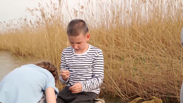 The Boy Helps the Girl to Strung Worm on a Fishing Hook