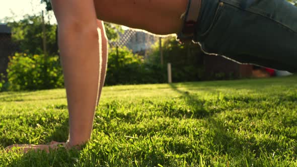 Wide pushups on prickly natural grass out in the sun