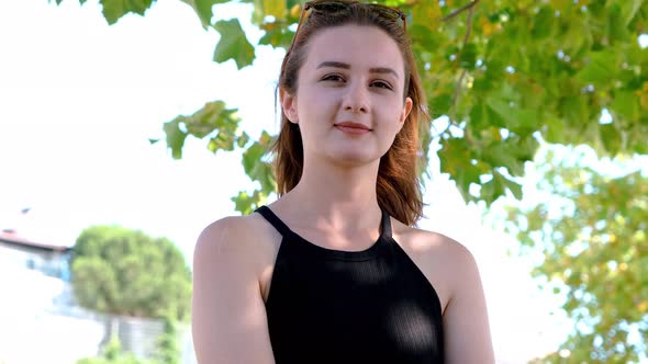 A portrait of young woman looking confident in a city park alone.