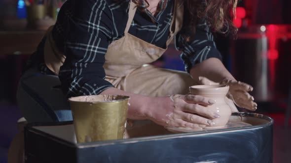 Pottery Crafting  Woman with Curly Hair Making a Pot Out of Wet Clay Using a Little Sponge