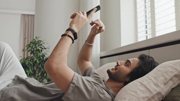 Man Scrolling Feed in Bed