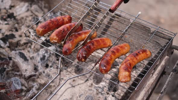 Closeup View of Tasty Sausages Grilling on Charcoal Grill Grate