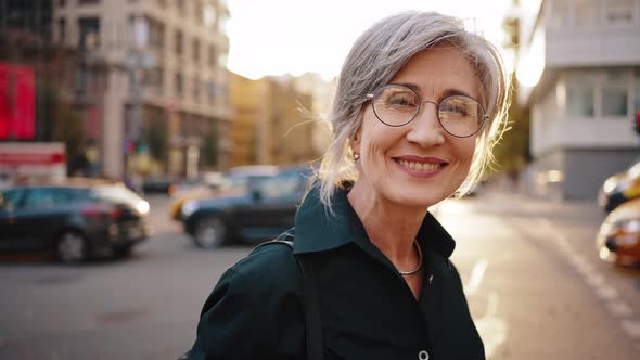 Close Up Portrait of a Mature Stylish Business Woman in the Middle of a Busy City Street in the