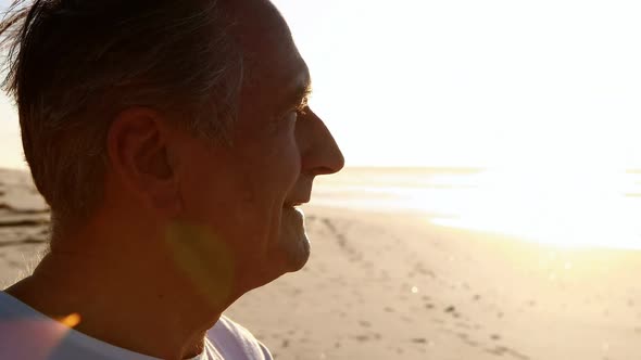 Smiling senior man standing on beach