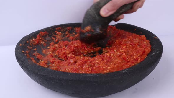 Full Shot smashing Indonesian Tomato Sambal In A Stone smasher Stock Video