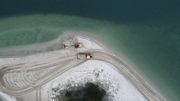 High view of a dump truck carting sand along a coastal headland for a erosion replenishment project.