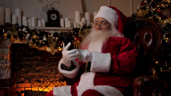 Santa Claus Works on Smartphone Buys Christmas Gifts on Internet for Children