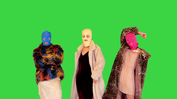 Young Daring Girls in Balaclavas Taking Different Poses in Front of Camera on a Green Screen Chroma