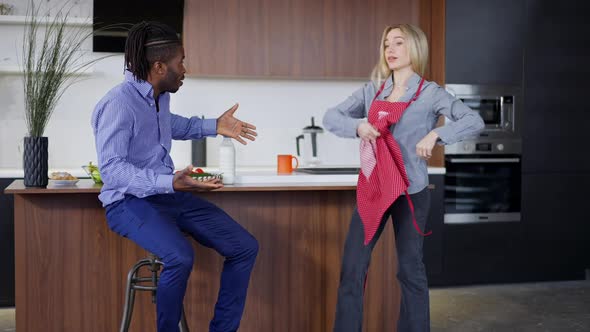 Wide Shot of Angry Caucasian Woman Arguing with African American Man in Kitchen at Home