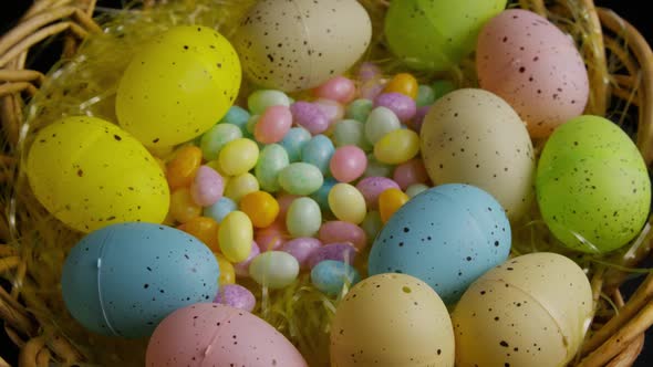 Rotating shot of Easter decorations and candy in colorful Easter grass 