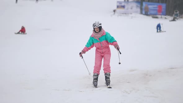 Wide Shot of Female Tourist Skiing on Snowy Slopes Outdoors