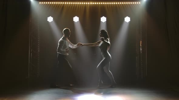 Young Couple Dancing Latin Music. Bachata, Merengue, Salsa. Shot in a Dark Studio with Neon Lights