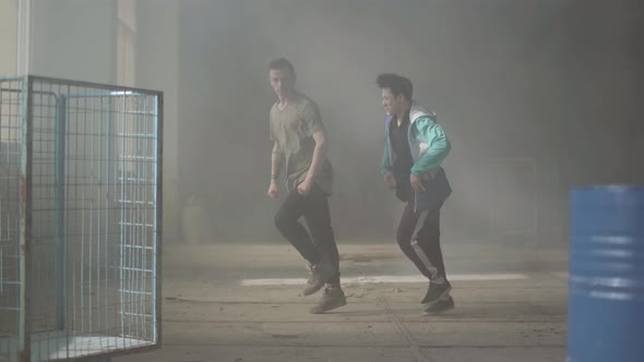 Two Skillful Young Friends Dancers Dancing in the Dark and Dusty Room of Abandoned Building