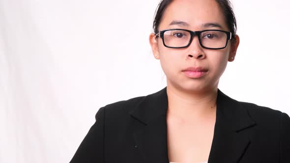 Confident Asian businesswoman looking at camera on white background in studio.