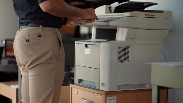 Man Finger Press Buttons On Multifunctional Copier. Man Using Printer Or Scanner In Office.Workplace