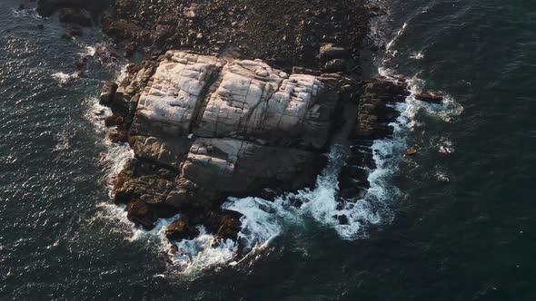 Morning Sunlight On The Rocky Coast Surrounded By Dark Blue Ocean With Waves Splashing In Gloucester