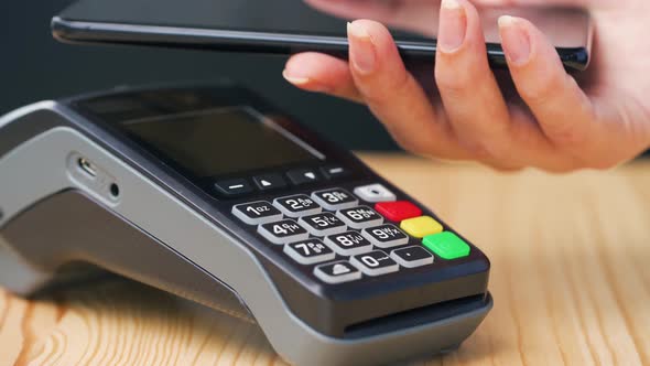 Contactless Payment with Smartphone. Wireless Payment Concept. Close-up, Woman Using Smartphone