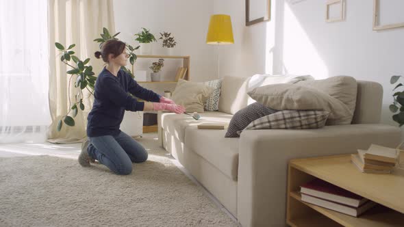 Happy Woman Having Fun while Cleaning Couch