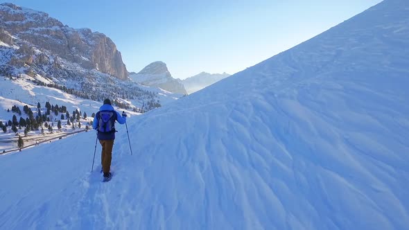 Man snowshoeing in the dolomites at sunrise