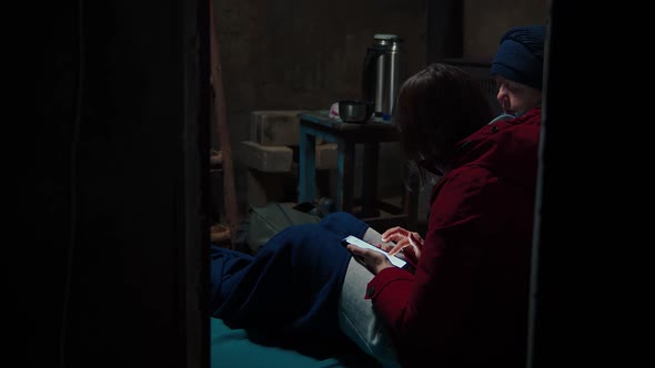 A Woman Using a Phone When Hiding in a Shelter