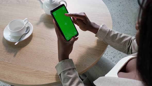 AfroAmerican Woman Touches Phone Chromakey Screen in Cafe