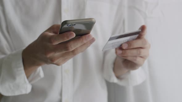 Close-up hands businessman holding credit card and using smartphone purchase online shopping.