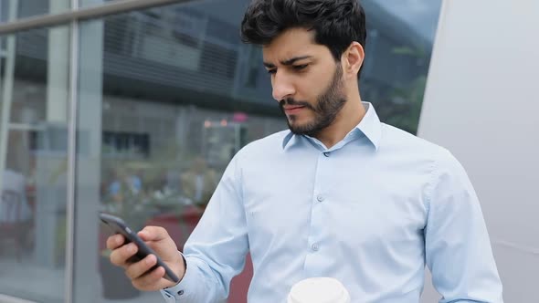 Handsome Man With Phone Drinking Coffee Near Business Office