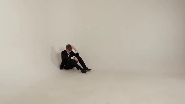Guy Sitting In Empty Room On White Background. Concept Of Loneliness.