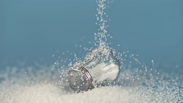 Super Slow Motion Drop Salt on a Salt Shaker on Blue