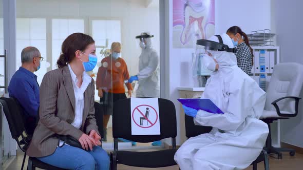 Dentist Assistant with Ppe Equipment Talking with Patient