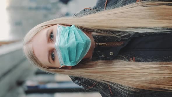 Young Blonde Woman Wearing a Protective Medical Mask on the Street