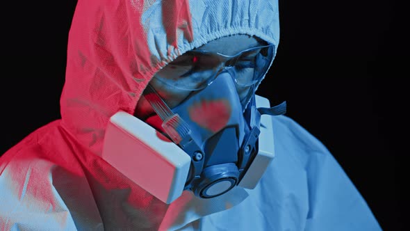 Doctor microbiologist scientist in a protective PPE suit. Working at a computer