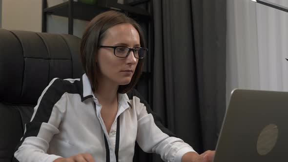 Focused smart attractive businesswoman is working on laptop.