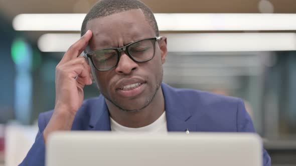 Young African Businessman with Laptop Having Headache