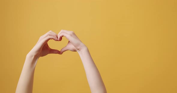 Young Beautiful Girl Makes Heart By Her Hands in Heart Shape