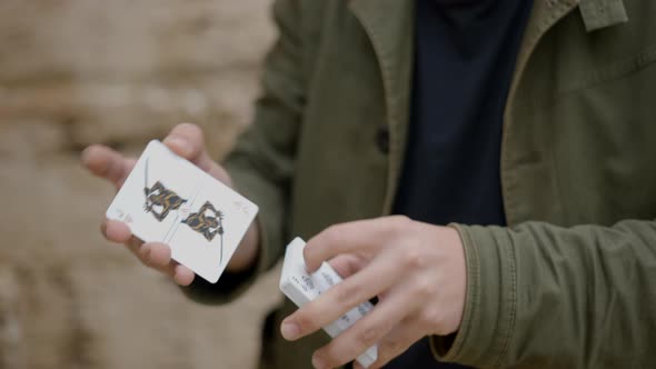 Close Up Shot of a Male Magician's Hands Showing Trick with Cards Along the Roadside at Daytime