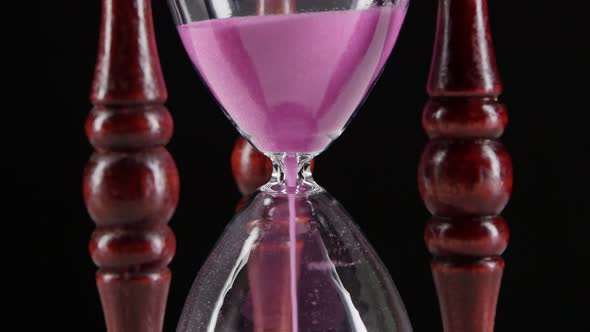 Sand Flowing Through an Hourglass. Black. Close Up