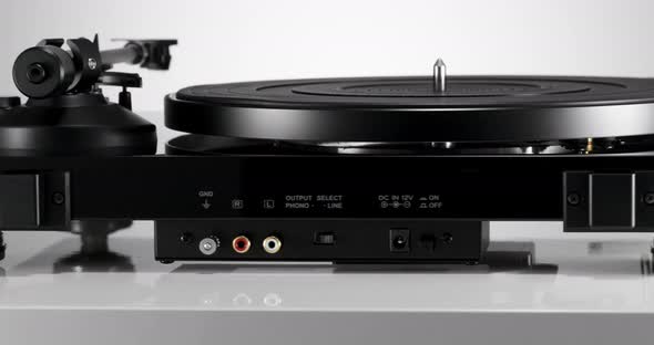 Black Varnished Record Player Spinning on White Table