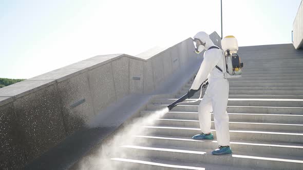 Young Sanitation Worker in Hazmat with Pressure Washer Outdoors