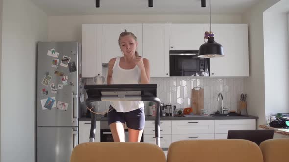 Woman Running on Running Machine at Home