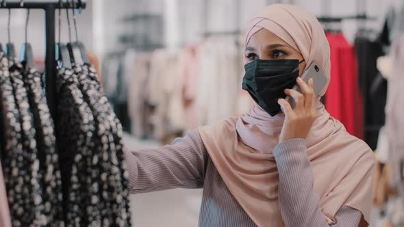 Closeup Young Muslim Woman in Medical Protective Mask Talking on Cell Phone with Friends Uses