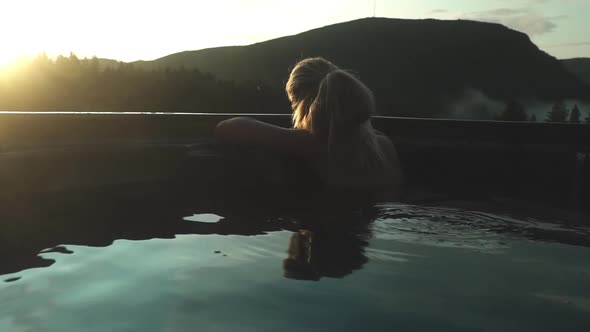 Woman Relaxing In Hot Tub At Sunset
