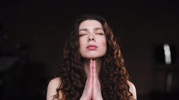 Close-up of a Young Girl with Long and Curly Hair, Deep Breathing While Doing Yoga. Camera Zoom in